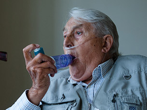 &Auml;lterer Herr mit Nasenkan&uuml;le bei der Verwendung des Spacers OptiChamber Diamond mit seinem Inhalator
