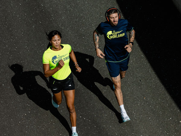 Zwei L&auml;ufer geben alles, um schneller als das Catcher Car zu sein.