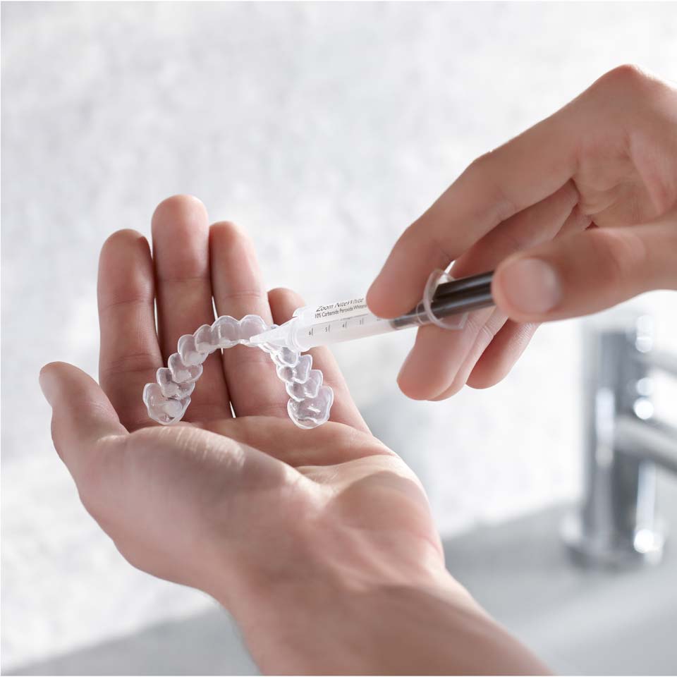 Patient gibt Aufhellungsgel auf die individuelle Schiene